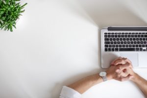 Hands Folded at Computer